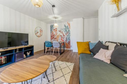 un salon avec un canapé et une table dans l'établissement Appartement du Thiou - Welkeys, à Annecy