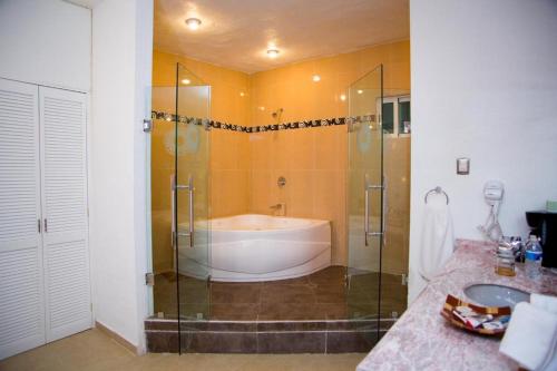 La salle de bains est pourvue d'une baignoire, d'une douche et d'un lavabo. dans l'établissement Nuevo Amanecer, à Tepoztlán