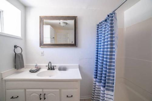 a bathroom with a sink and a blue shower curtain at Netflix, Bikes, Stocked Kitchenette, Beach Gear in Ventura
