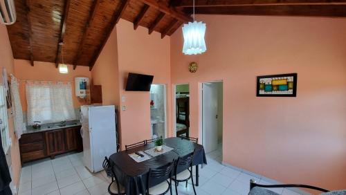 a kitchen with a table with chairs and a refrigerator at El Olimpo in Wanda