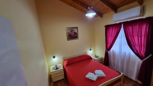 a bedroom with a red bed with red curtains at El Olimpo in Wanda