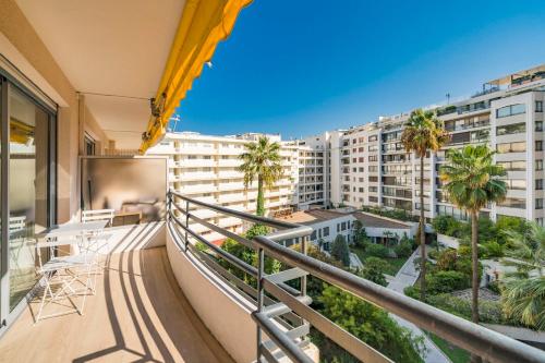 d'un balcon avec vue sur les palmiers et les bâtiments. dans l'établissement Brand new one bedroom 2min walk to Carlton hotel, à Cannes