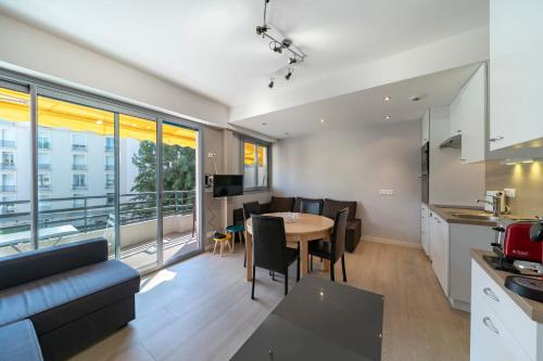 une cuisine et un salon avec une table et des chaises dans l'établissement Brand new one bedroom 2min walk to Carlton hotel, à Cannes
