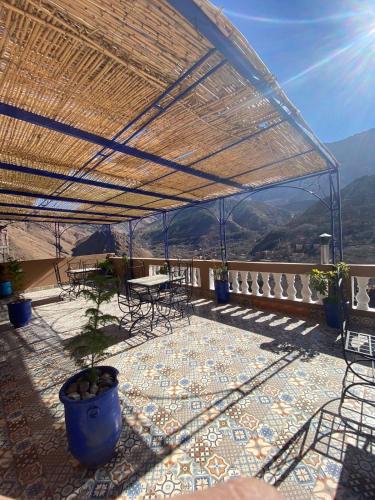 a patio with a table and chairs and a roof at Amazigh Family Riad in Imlil