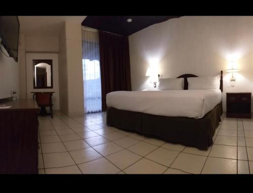 1 dormitorio con 1 cama grande en una habitación de hotel en HOTEL REAL FLOR DE MARIA, en Comitán de Domínguez