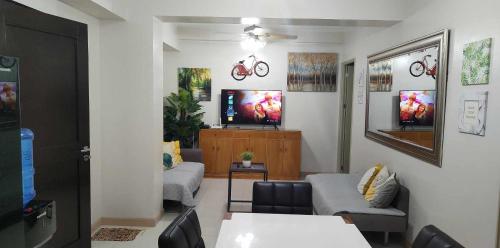 達沃市的住宿－1608 Three Bedrooms With 1 free parking, swimming pool WiFi and Netflix at Northpoint Camella Condominium Bajada Davao City，带沙发和电视的客厅