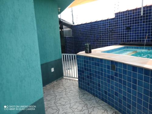 Baño de azulejos azules con piscina en Casa com piscina , churrasqueira, Wi-Fi, em rua de Areia à 1km da praia, bairro sussegado, proíbido uso de som extremamente alto ideal para descansar, en Itanhaém