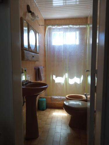 y baño con aseo, lavabo y ducha. en CasaMüna en San Antonio de Areco