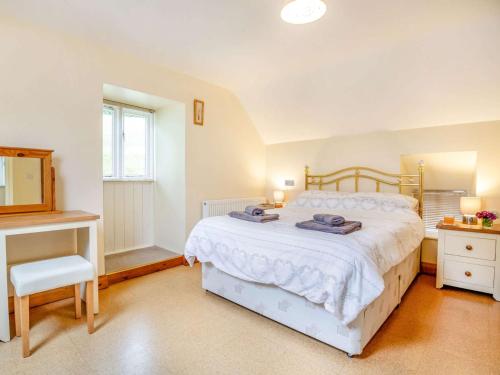 um quarto com uma cama branca e uma cadeira em 1 bed in Bala 88450 em Llandderfel