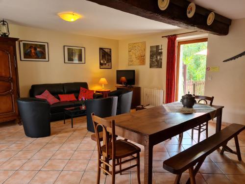 un salon avec une table et un canapé dans l'établissement Gîte en campagne proche Orléans et Blois avec jardin paysager, pour 6 pers., calme assuré - FR-1-590-109, à Saint-Ay