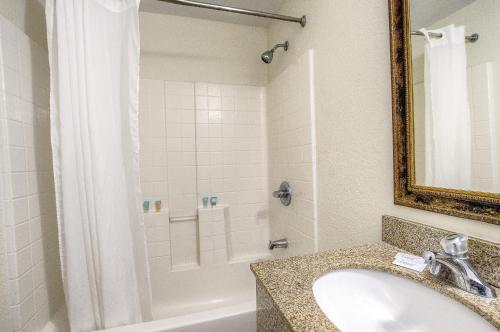 a bathroom with a sink and a shower and a tub at La Bella Oceanfront Inn - Daytona in Daytona Beach