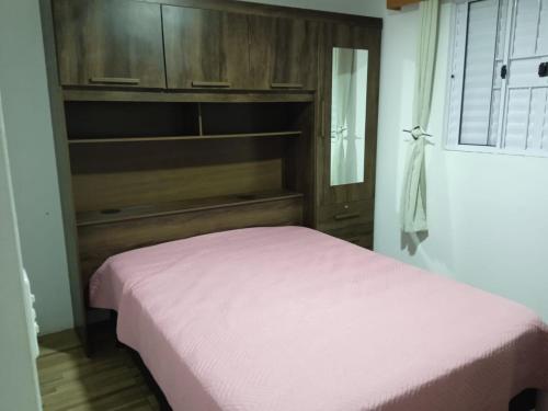 1 dormitorio con 1 cama con cabecero de madera en Casa no Campeche para veraneio com internet, en Florianópolis