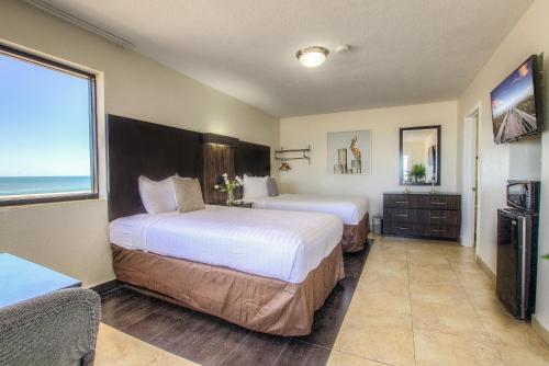 una camera d'albergo con due letti e una grande finestra di La Bella Oceanfront Inn - Daytona a Daytona Beach