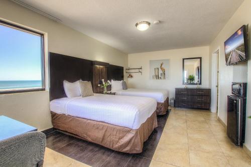 デイトナビーチにあるLa Bella Oceanfront Inn - Daytonaのベッドが2つあり、大きな窓があるホテルの部屋