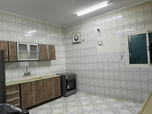 a tiled kitchen with a stove and a sink at Albayt Private Properity Appartment in Al Madinah