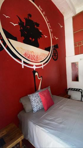 a bedroom with a bed with a large mirror on the wall at Chuchumbé Hotel & Hostal in Veracruz