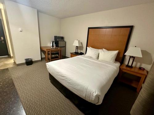 a bedroom with a large bed with white sheets and pillows at Anavada Inn & Suites - Grande Prairie in Grande Prairie