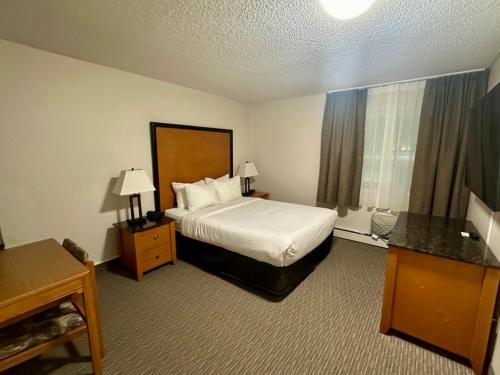 a hotel room with a bed and a window at Anavada Inn & Suites - Grande Prairie in Grande Prairie