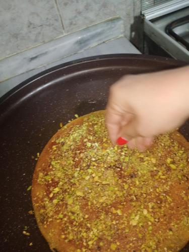 a person is cooking food in a pan at Petra Musa Rural House in Wadi Musa