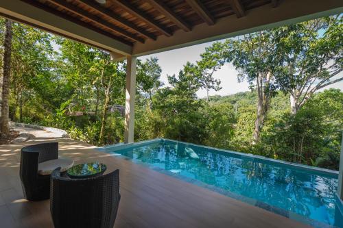 an infinity pool in a house with a view of the forest at El Jardin Lodge & Spa in Puerto Misahuallí