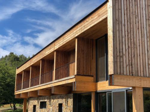 a building with wooden panels on the side of it at Calma Sur Hoteleria Boutique in Villa Meliquina