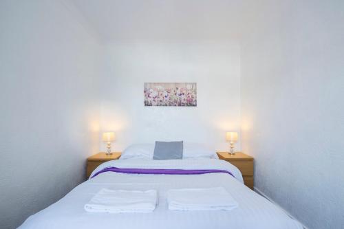 a bedroom with a white bed with two lamps at Rochester Slopes - Free Street Parking in Strood