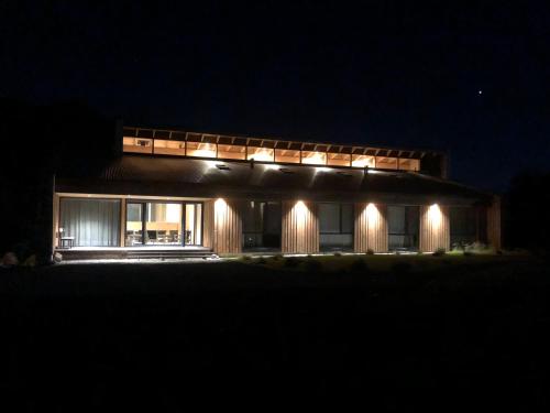 a house lit up at night with lights at Calma Sur Hoteleria Boutique in Villa Meliquina