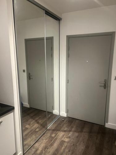 two glass doors in a room with wood floors at EFA in Villeurbanne