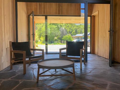 a living room with two chairs and a coffee table at Calma Sur Hoteleria Boutique in Villa Meliquina