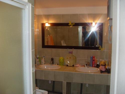 a person taking a picture of a bathroom with two sinks at Appartement 10 Des Acacias in Anduze