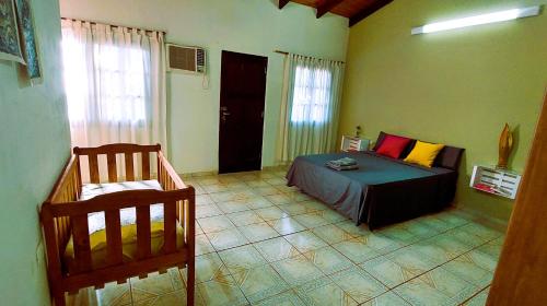 um quarto com uma cama e uma cadeira num quarto em Casa Yvy Pytã em Puerto Iguazú