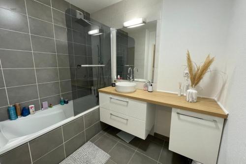 a bathroom with a sink and a bath tub and a sink at Le Panoramique- Air conditioning terrace and parking! in Saint-Brès