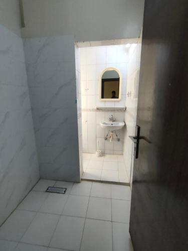 a white bathroom with a sink and a mirror at دانيال للشقق المفروشة in Al Madinah