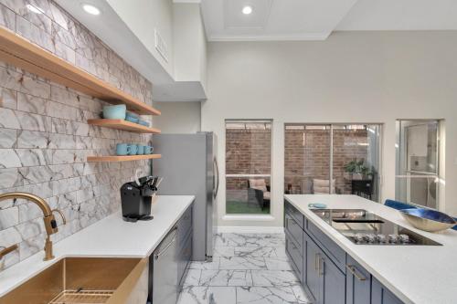 a kitchen with a sink and a refrigerator at Modern Accessible Houston Gem Jacuzzi & Air Hockey 6Beds in Houston