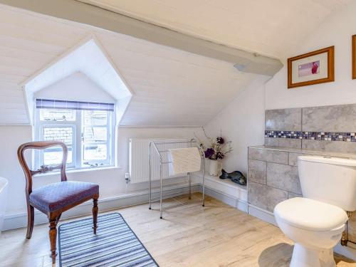 łazienka z toaletą, krzesłem i oknem w obiekcie 1 Bed in Presteigne 53667 w mieście Presteigne