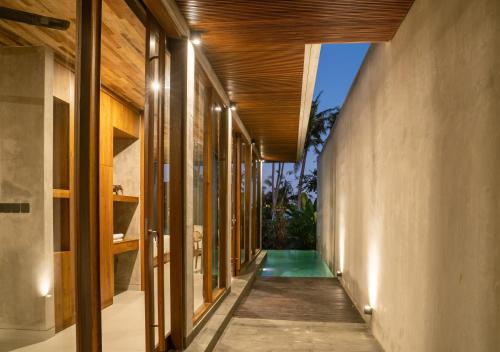 pasillo exterior de una casa con piscina en Langit Pitu Villas en Ketewel
