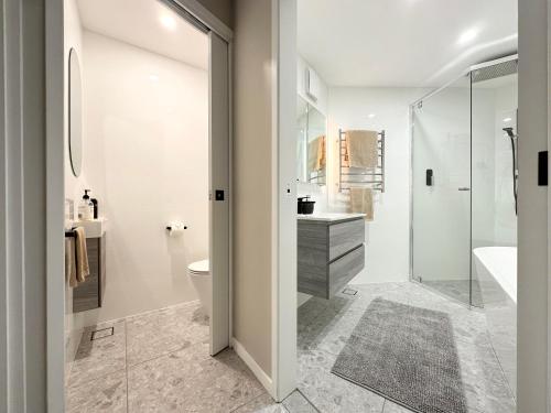 a bathroom with a shower and a toilet and a sink at Full Circle Apartments in Jindabyne