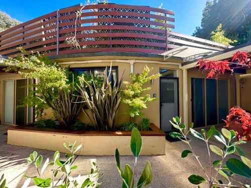 a house with plants in front of a building at Full Circle Apartments in Jindabyne