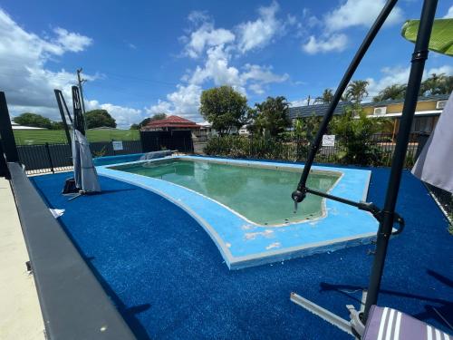 a swimming pool with a blue coating on it at Arkana Motel in Maryborough