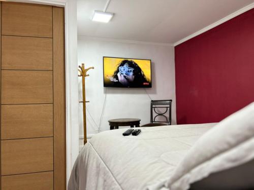 a bedroom with a bed and a tv on the wall at Casa Di Patti in Santiago