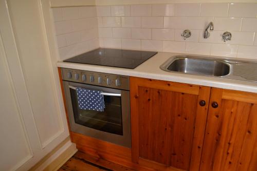 a kitchen with a sink and a stove at Robe House Heritage Accommodation in Robe