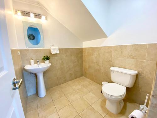 a bathroom with a toilet and a sink at Casa Azure Aruba in Palm-Eagle Beach