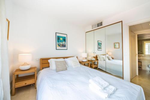une chambre avec un grand lit blanc et un miroir dans l'établissement Cannes banane beau 2 pièces, à Cannes