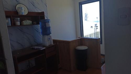 Hostal " Donde Alicia " في كارتاخينا: غرفة مع موزع للمشروبات على مكتب مع نافذة