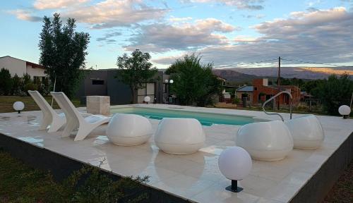 eine Gruppe weißer Stühle neben einem Pool in der Unterkunft Waylla in Panaholma