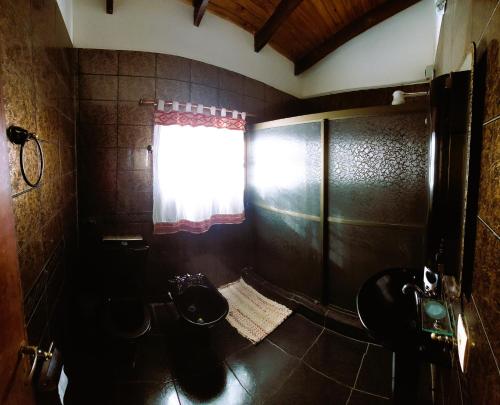 bagno con due servizi igienici e finestra di Casa Yvy Pytã a Puerto Iguazú