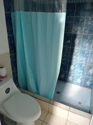 ein Bad mit einem WC und einem blauen Duschvorhang in der Unterkunft Casa Via Gutierrez in San José