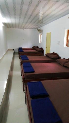 uma fila de camas alinhadas num quarto em Edakkal Cottages N Dormitory em Ambalavayal