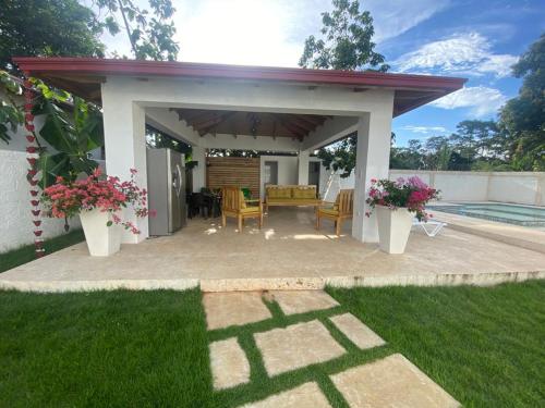 a pavilion with a table and chairs in a yard at Villa Grecko Place in Jarabacoa