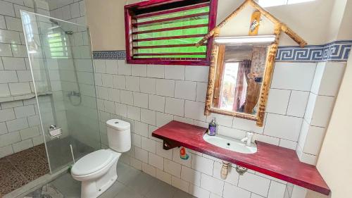 y baño con aseo, lavabo y espejo. en Sugesty Homestay, en Bumbang